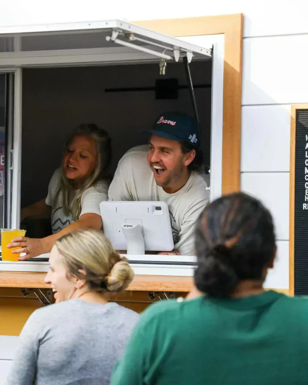 two people serving coffee out of a coffee camper