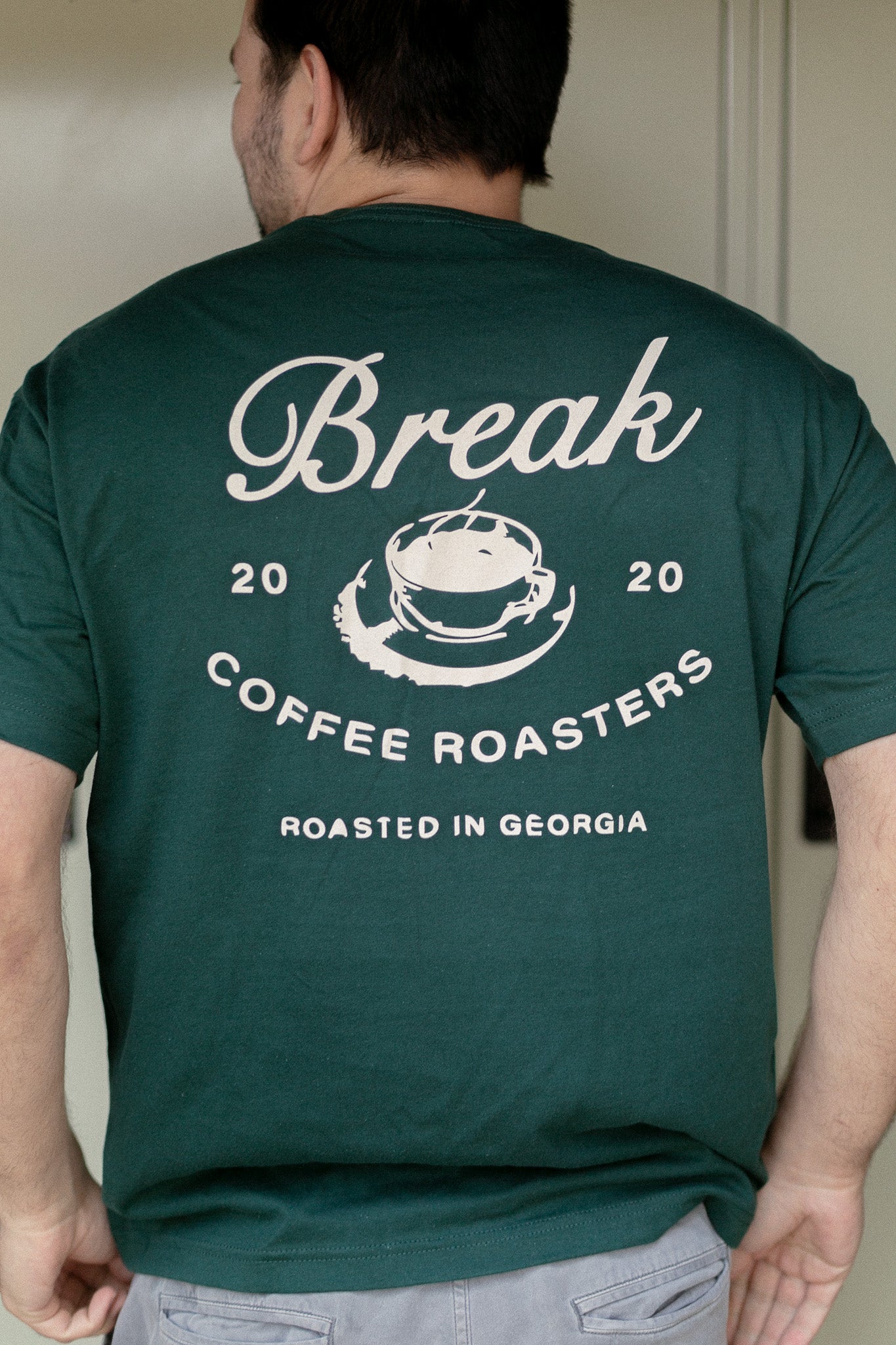 Person wearing a green t-shirt with 'Break Coffee Roasters' branding on the back.